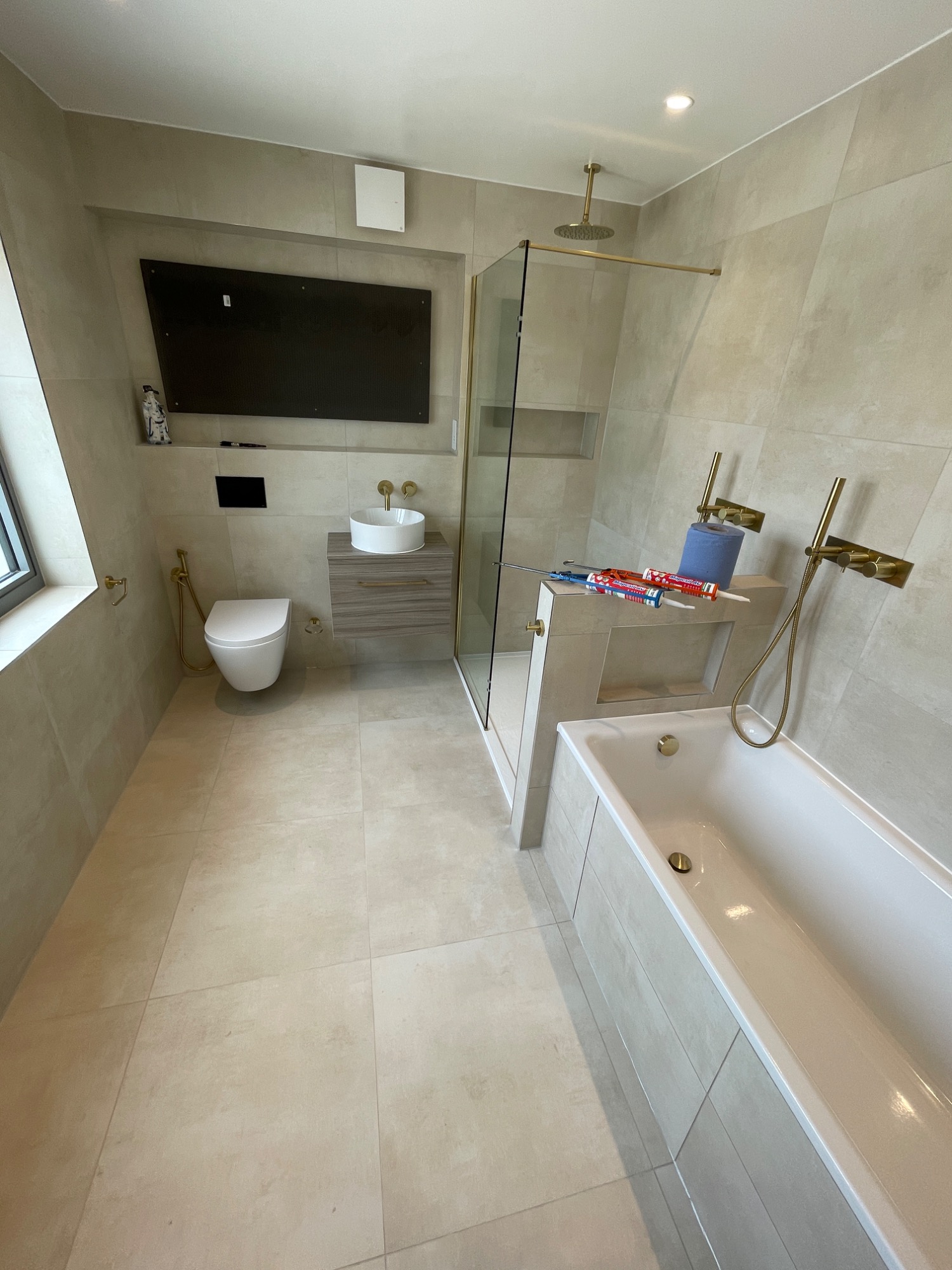 Modern bathroom featuring a shower, bathtub, toilet, and a minimalist design.